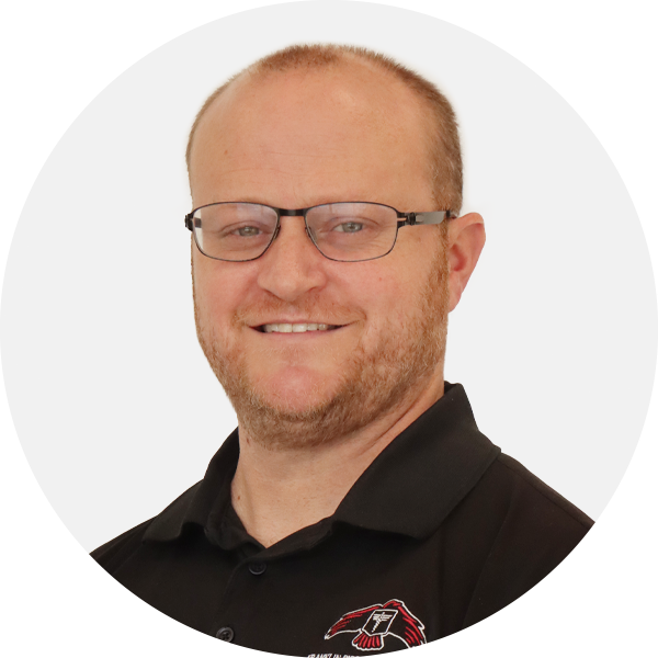 Headshot of a smiling man wearing glasses and a black polo shirt with a logo.