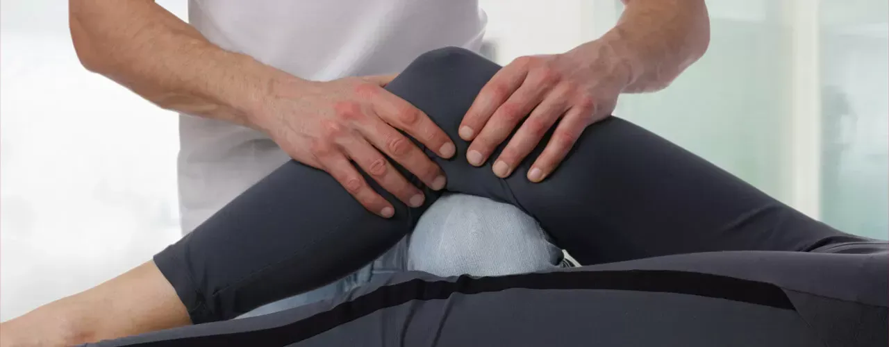Hands pressing on a person’s lower back during a massage treatment