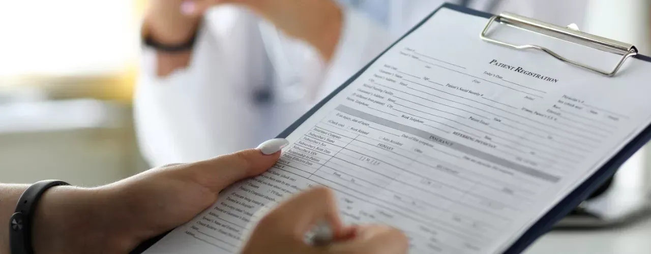 Person holding a clipboard with a form in a bright office setting