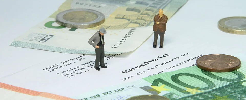 Zwei Figuren stehen auf einem Blatt Papier mit Geld und Münzen.