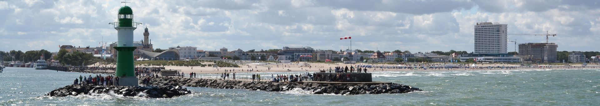 Ein grün-weißer Leuchtturm inmitten eines Gewässers