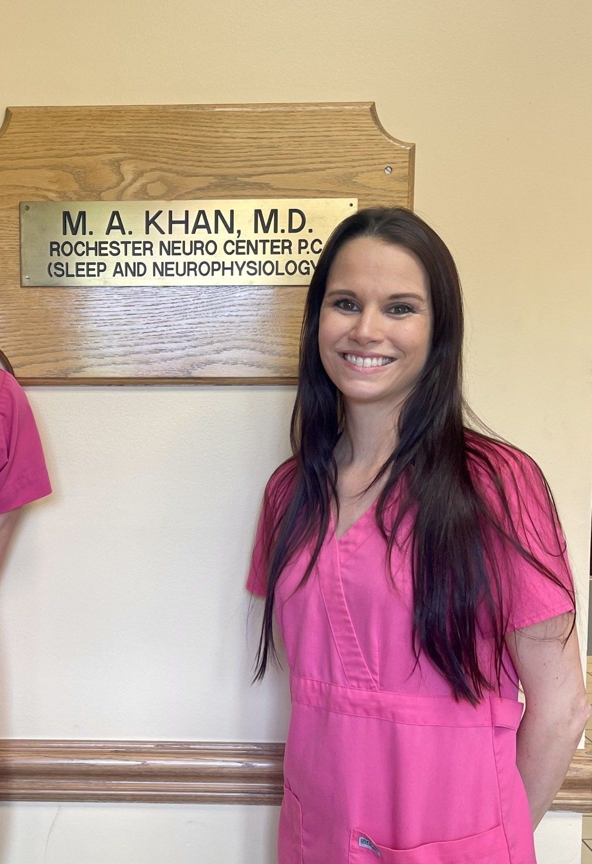 Two women standing next to each other in front of a sign that says m.a. khan m.d.