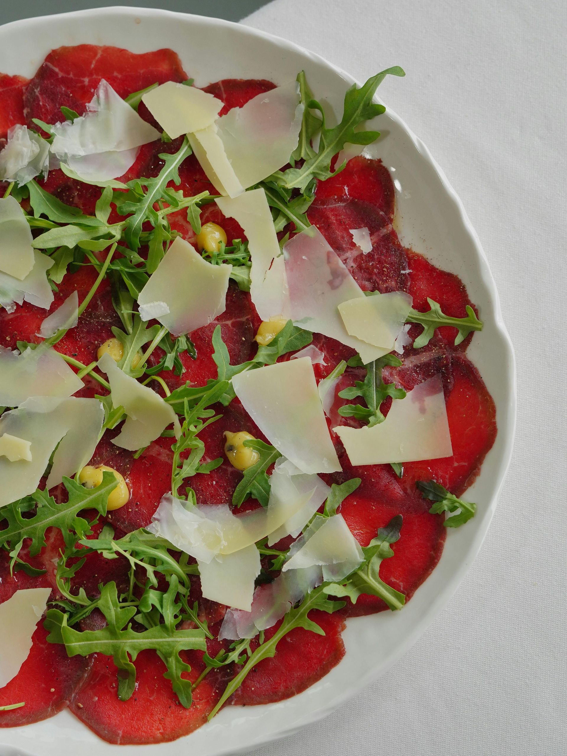 Une assiette blanche garnie de viande tranchée et de légumes