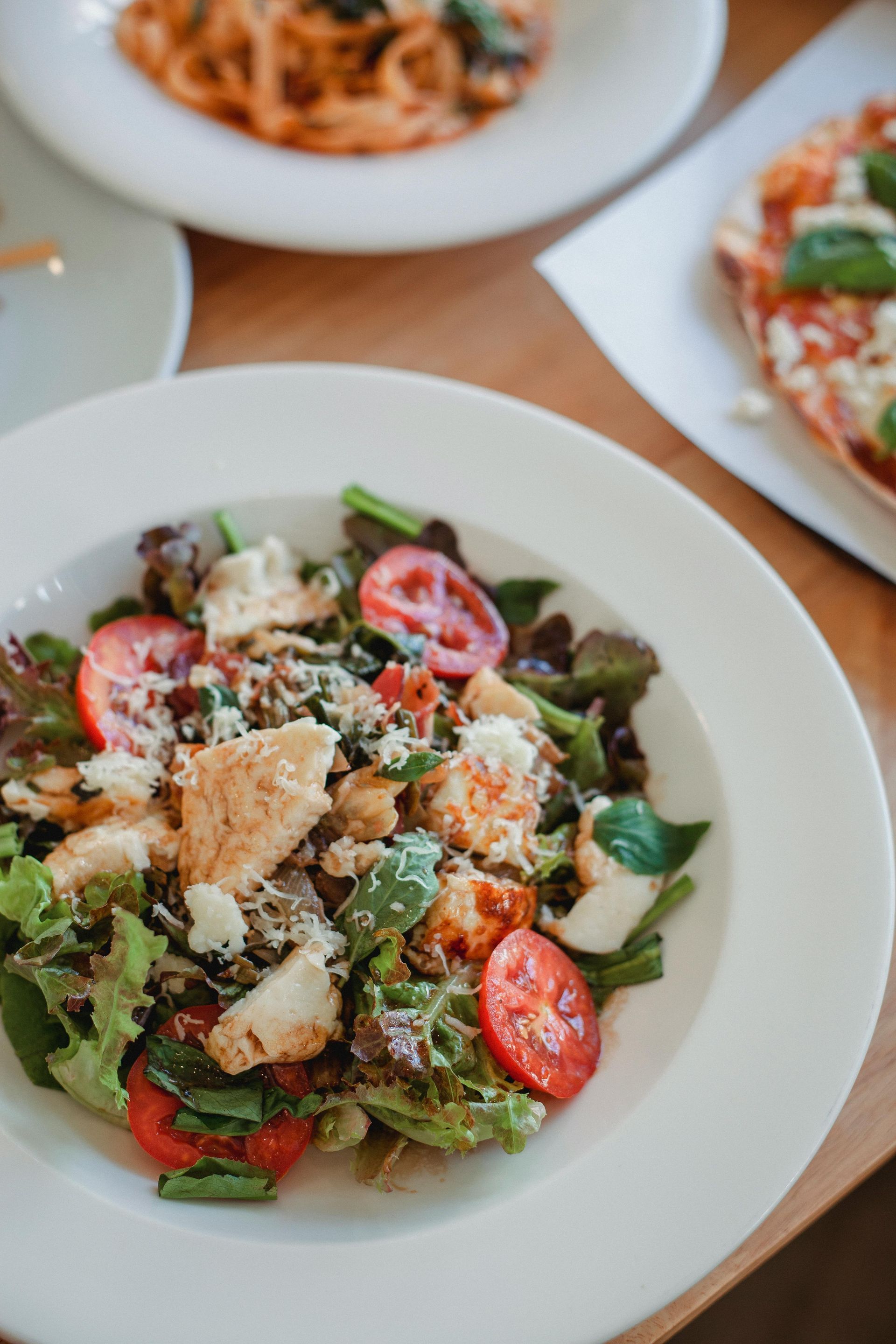 Un gros plan d'une salade dans une assiette sur une table.