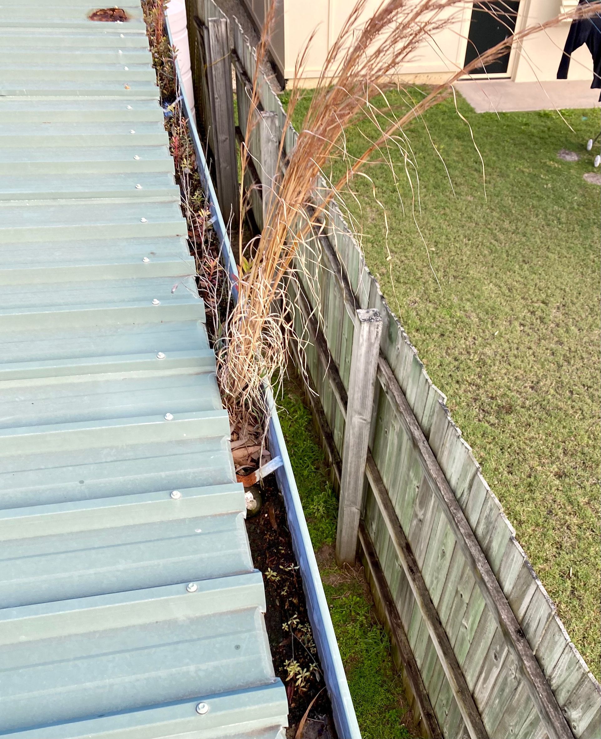 A Man Is Working On A Roof With A Harness On — Freshwater Exterior Cleaning in Lennox Head, NSW
