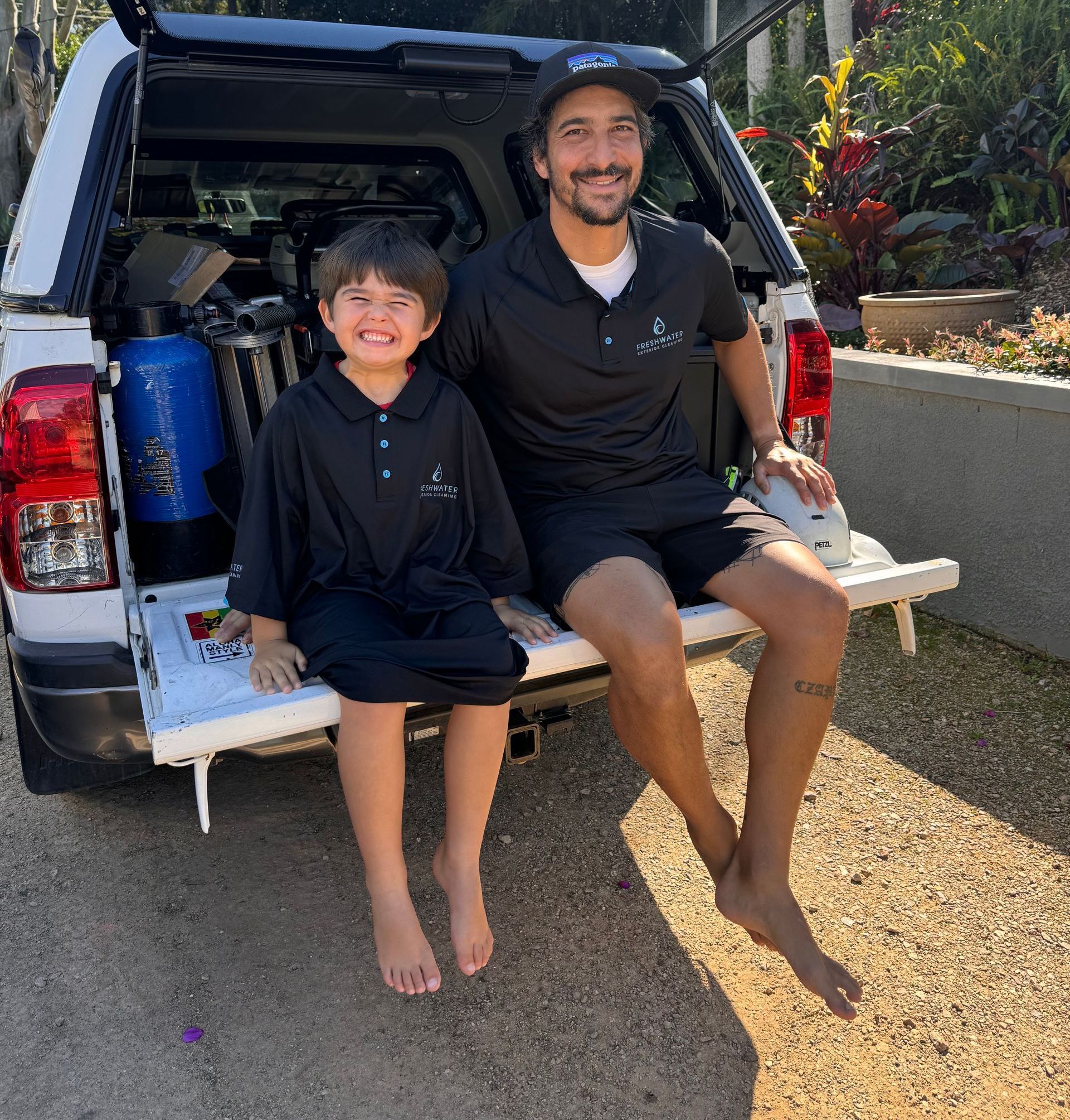 A Man With Son Sitting On End Of Ute After Cleaning Job — Freshwater Exterior Cleaning in Bangalow, NSW