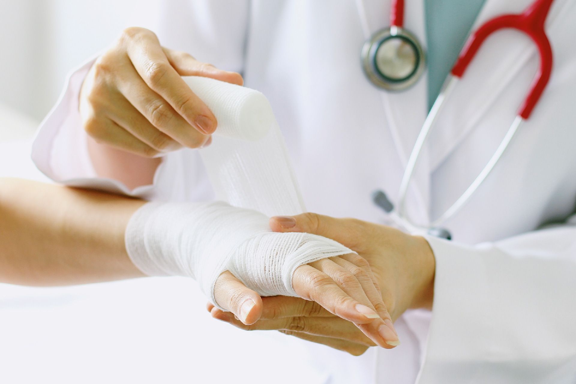 Un médico está vendando la muñeca de un paciente.