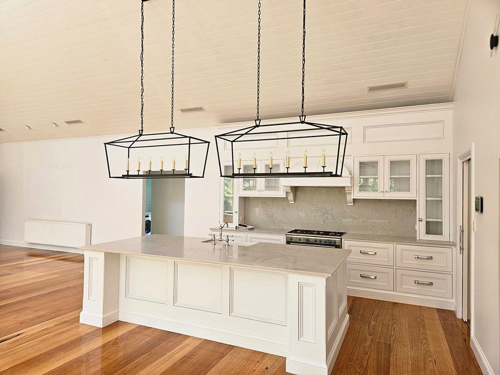 Beautiful White Kitchen With Two Chandelier Lights And Wooden Floor — A Perfect Move And Clean In Welby NSW 