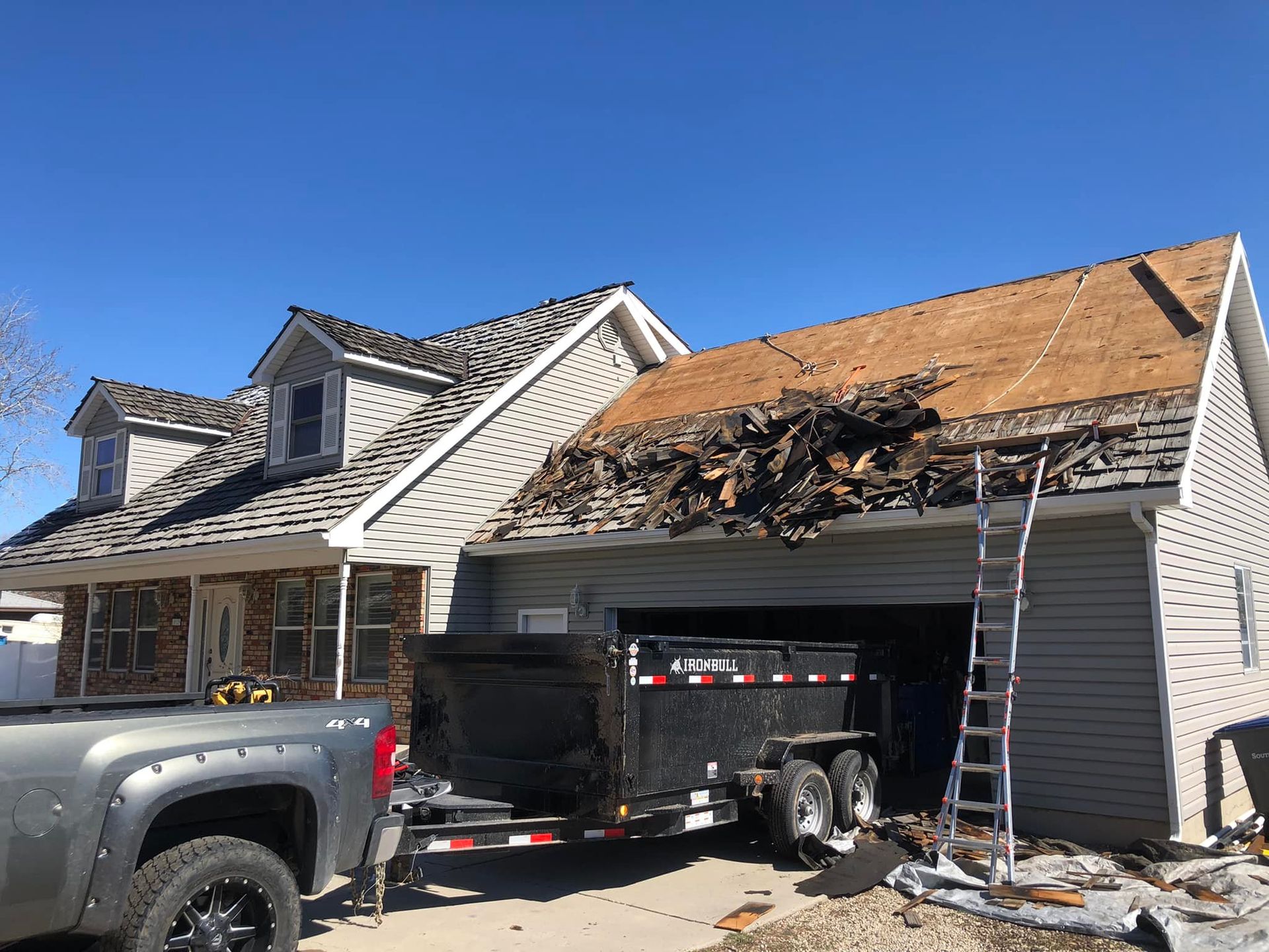 A truck is parked in front of a house with a trailer attached to it.