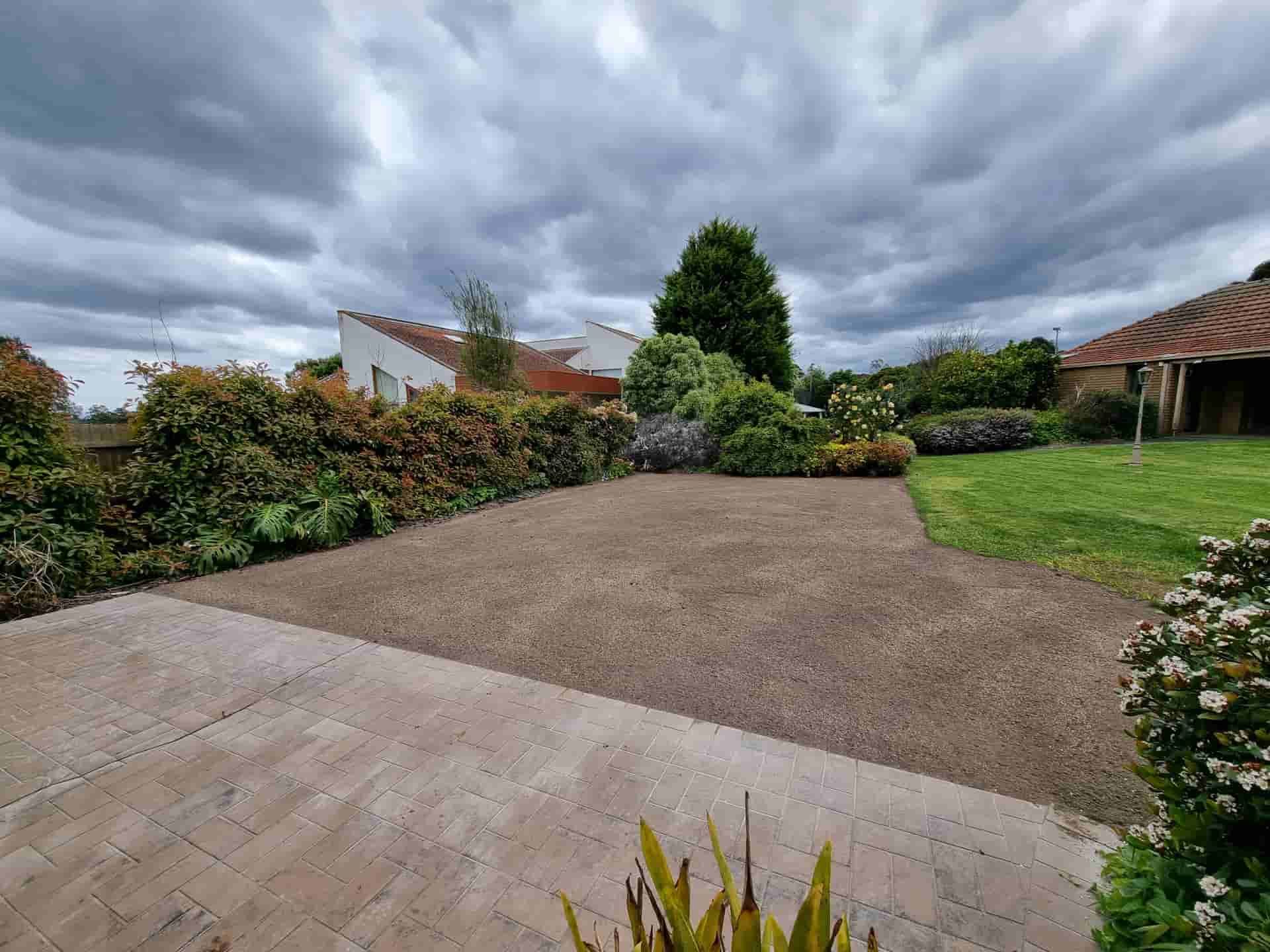 A Gravel Driveway Area Framed by a Paved Patio, Lush Green Hedges — All Over Pool Removals in Lilydale, VIC