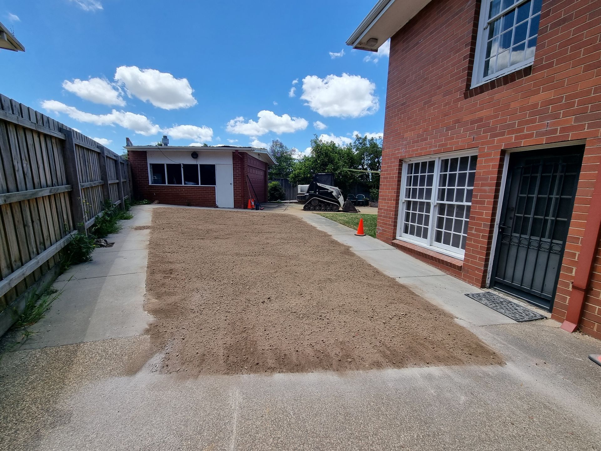 A Patch of Fresh Dirt is Centred Between a Red Brick House — All Over Pool Removals in Surrey Hills, VIC