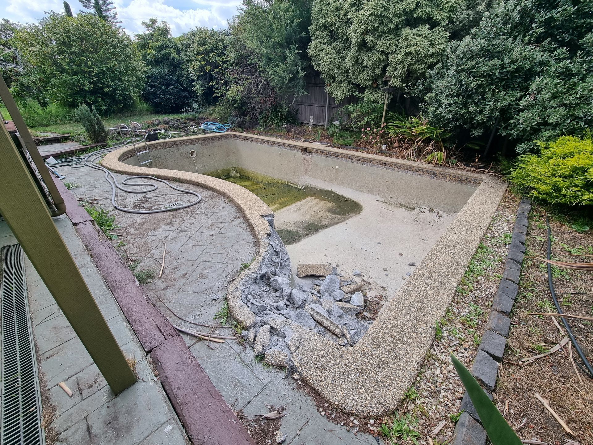An Empty, in-ground Swimming Pool With Exposed Aggregate Coping — All Over Pool Removals in Lilydale, VIC