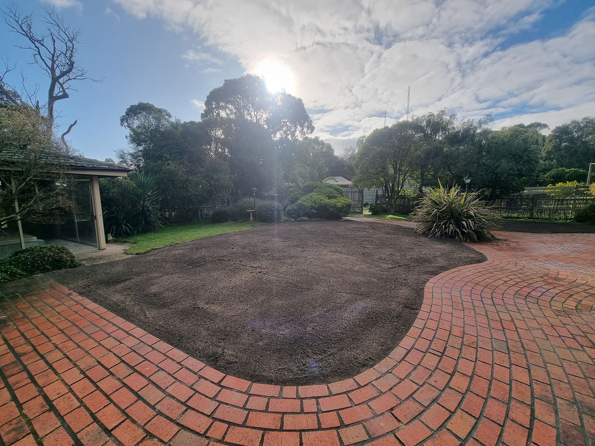 A Freshly Mulched Garden Bed Sits Next to a Curving Red Brick Patio — All Over Pool Removals in Donvale, VIC