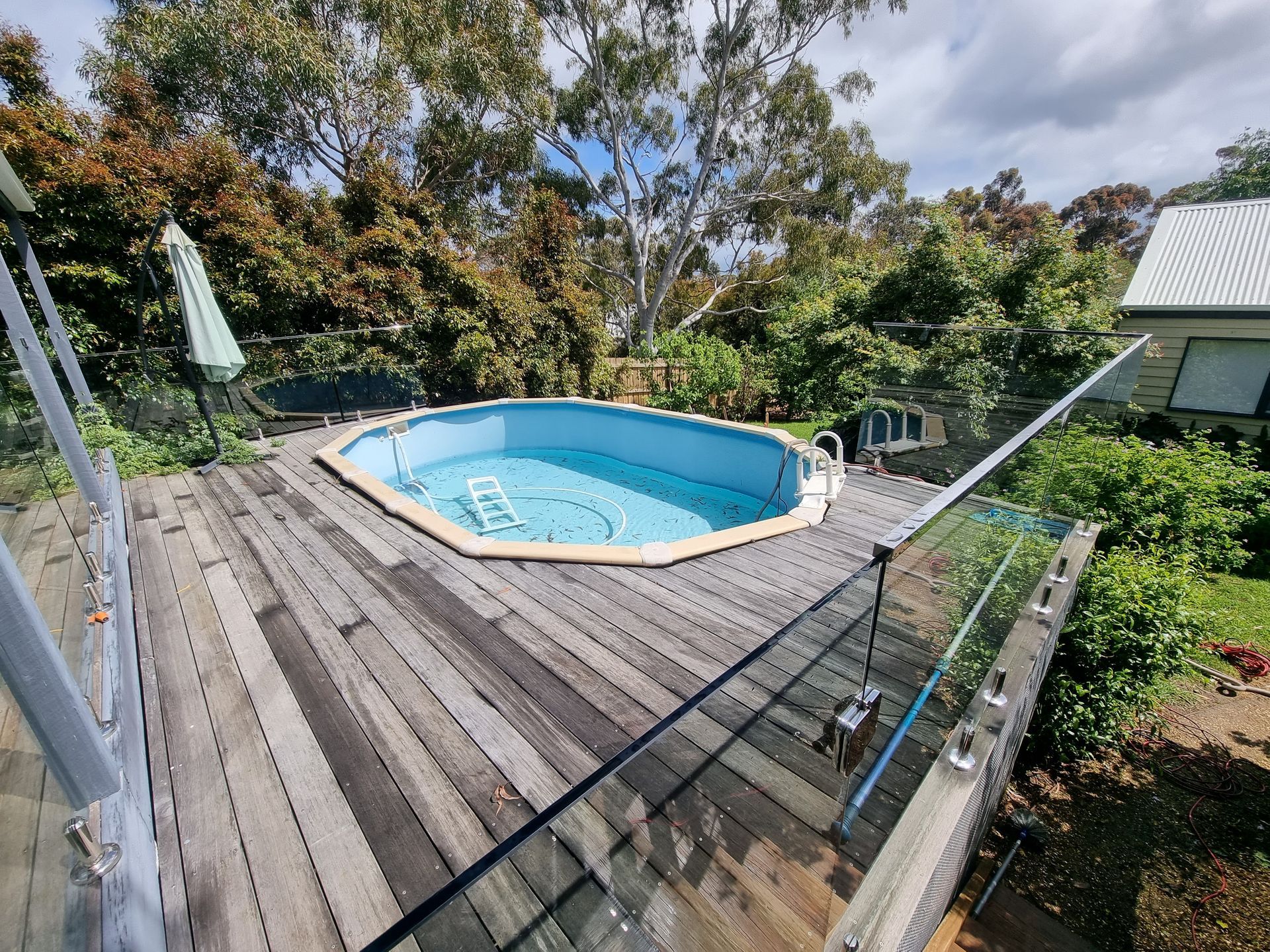 An Octagonal Above-ground Swimming Pool Set Into a Weathered Wooden Deck — All Over Pool Removals in Beaumaris, VIC