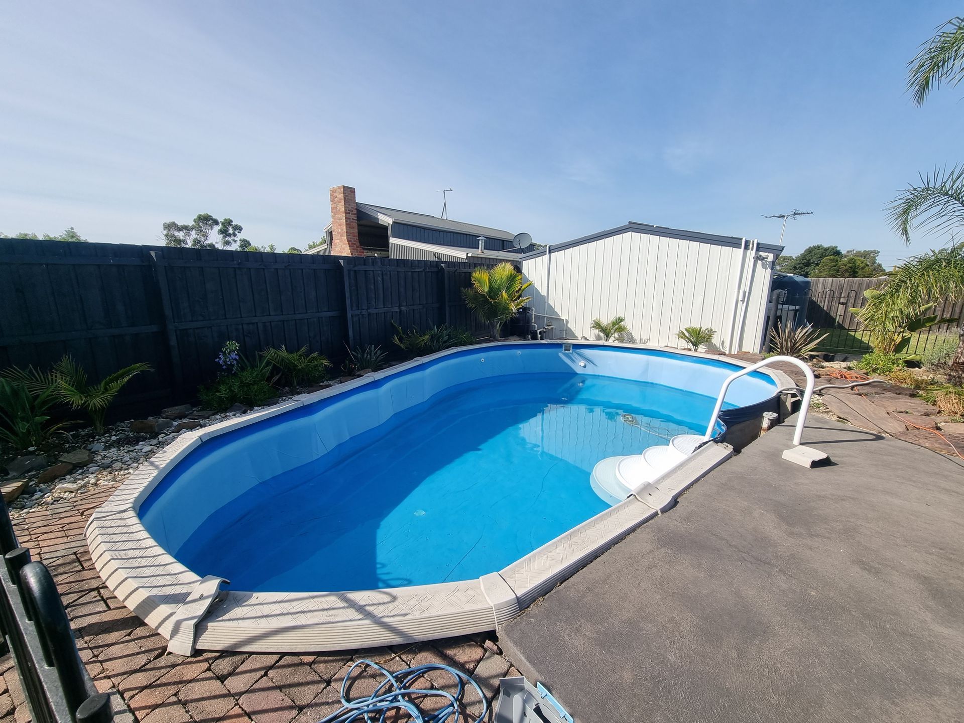 An Oval Above-ground Swimming Pool With Blue Water, Surrounded by Brick Paving — All Over Pool Removals in Chadstone, VIC