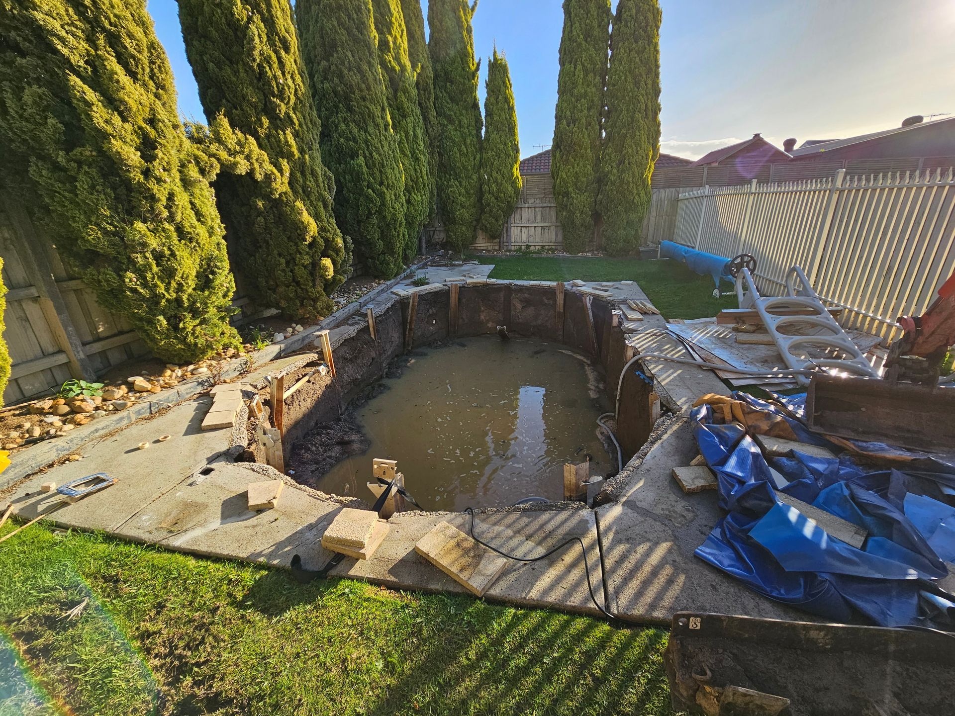 Empty Backyard Pool Under Renovation, Surrounded by Stones — All Over Pool Removals in Upwey, VIC