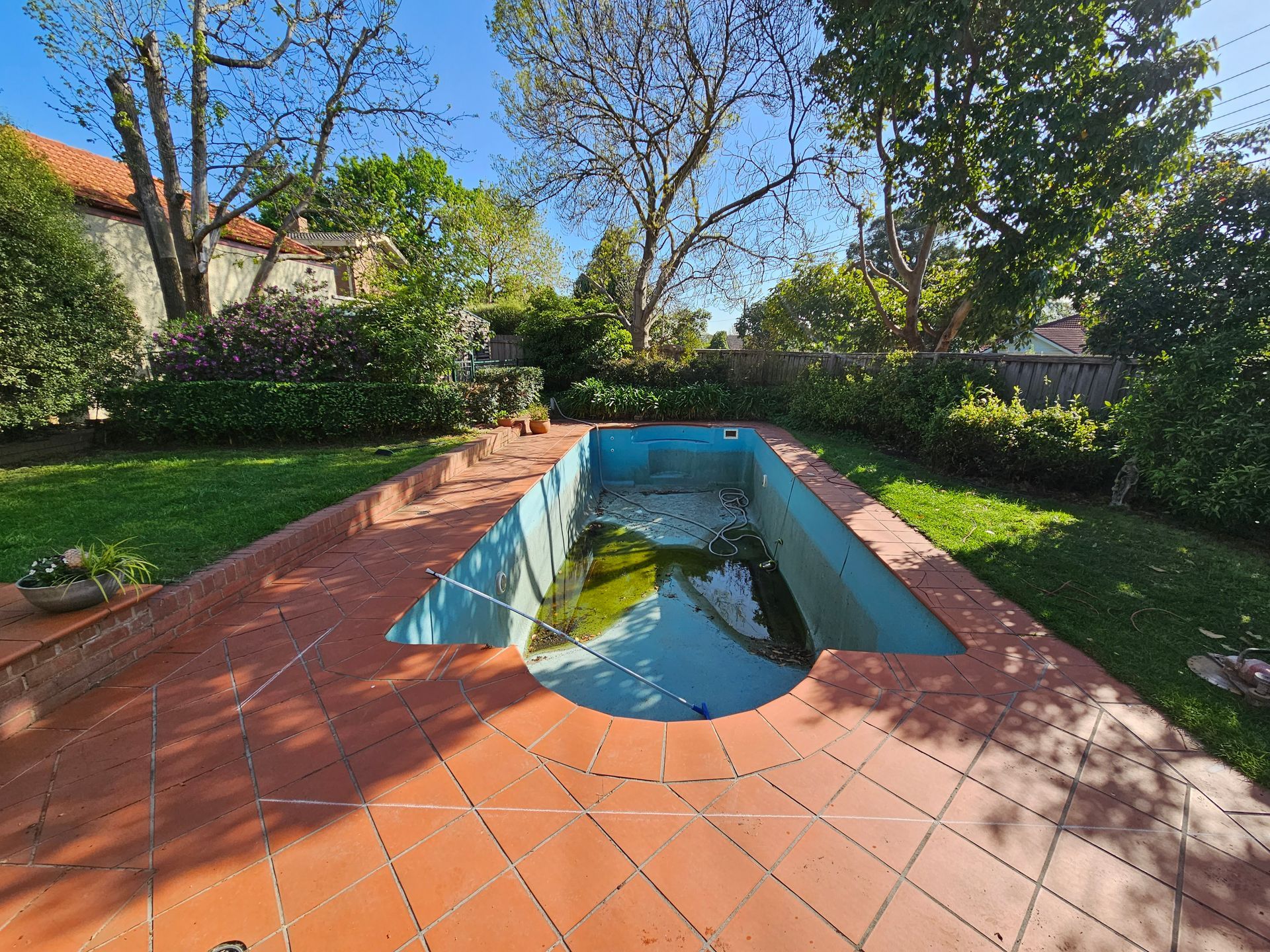 Empty Backyard Pool Surrounded by Red Tile Patio — All Over Pool Removals in Upwey, VIC