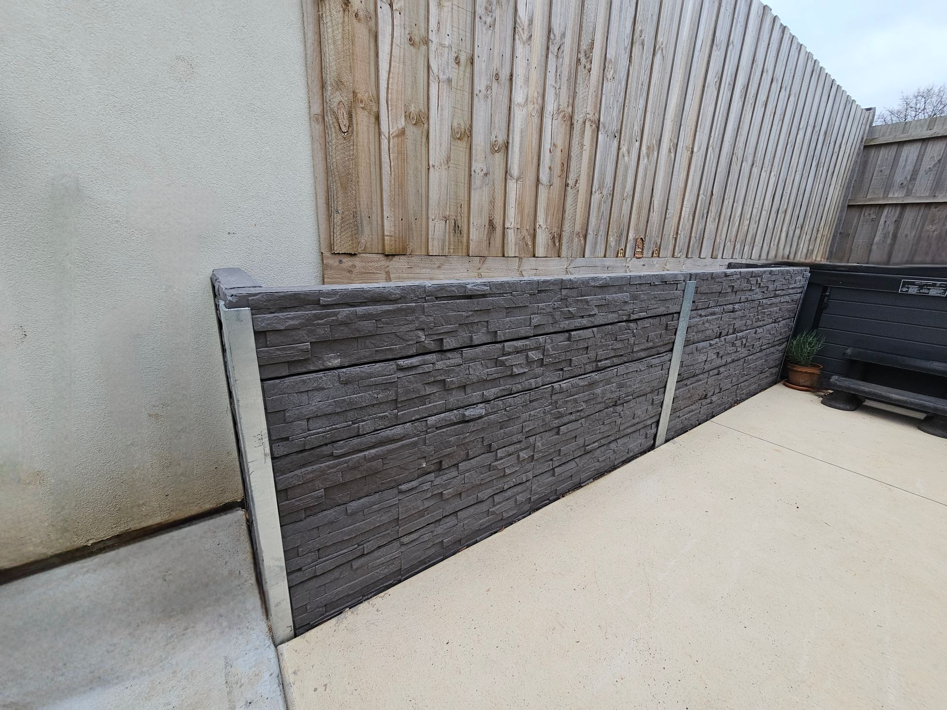 Backyard Corner With a Gray Brick Retaining Wall — All Over Pool Removals in Upwey, VIC
