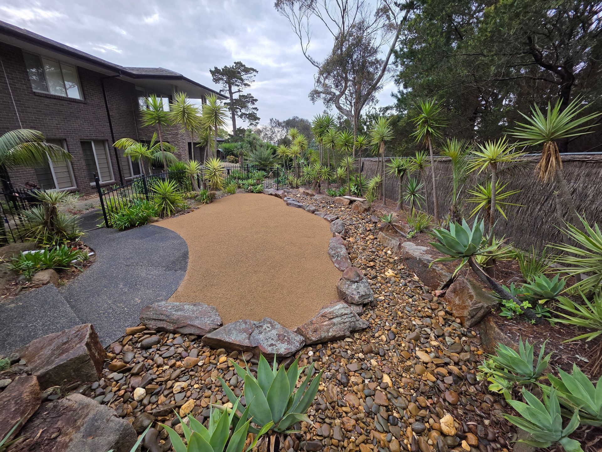 A Cleared, Flat Patch of Dirt in a Backyard With Trimmed Hedges, Palm Trees — All Over Pool Removals in Upwey, VIC