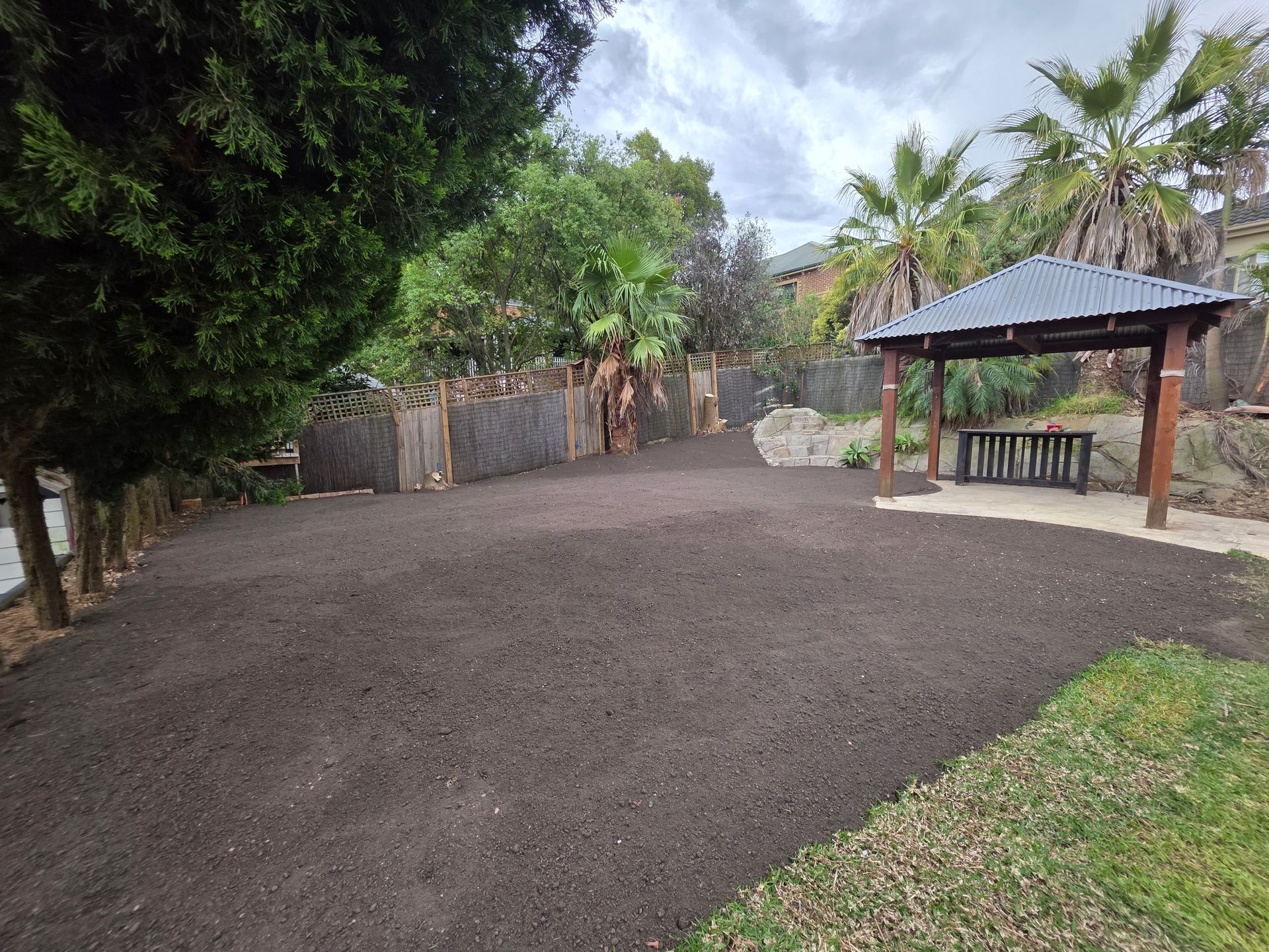 Gravel Courtyard With Trees, a Fence, and a Small Covered Picnic Shelter — All Over Pool Removals in Upwey, VIC