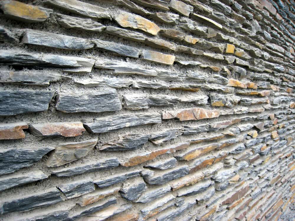 Stone Wall, Grey and Tan, With Rough-hewn Rectangular Stones Set in Mortar — All Over Pool Removals in Chadstone, VIC