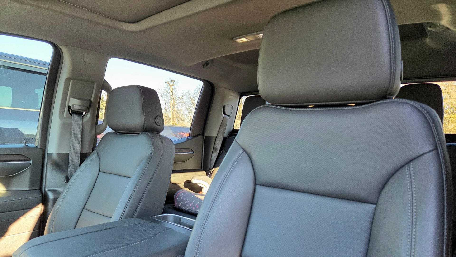 Interior view of a vehicle cabin with gray leather seats and headrests visible from the front passenger side.
