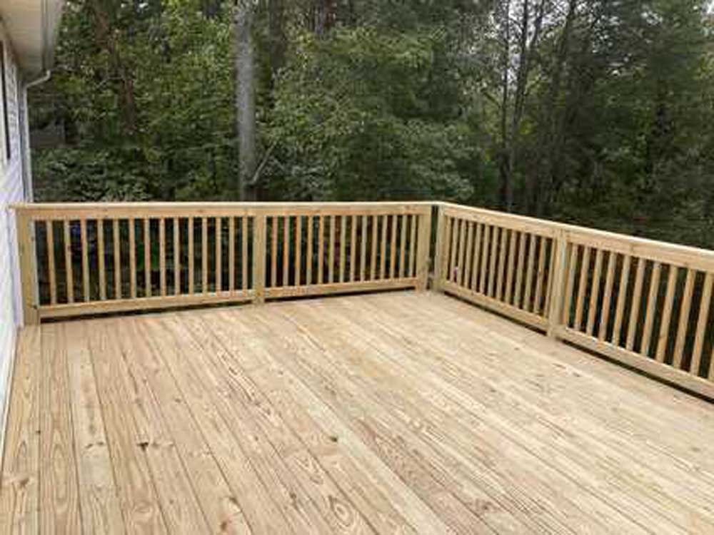 Wooden deck with light railings overlooking a wooded area