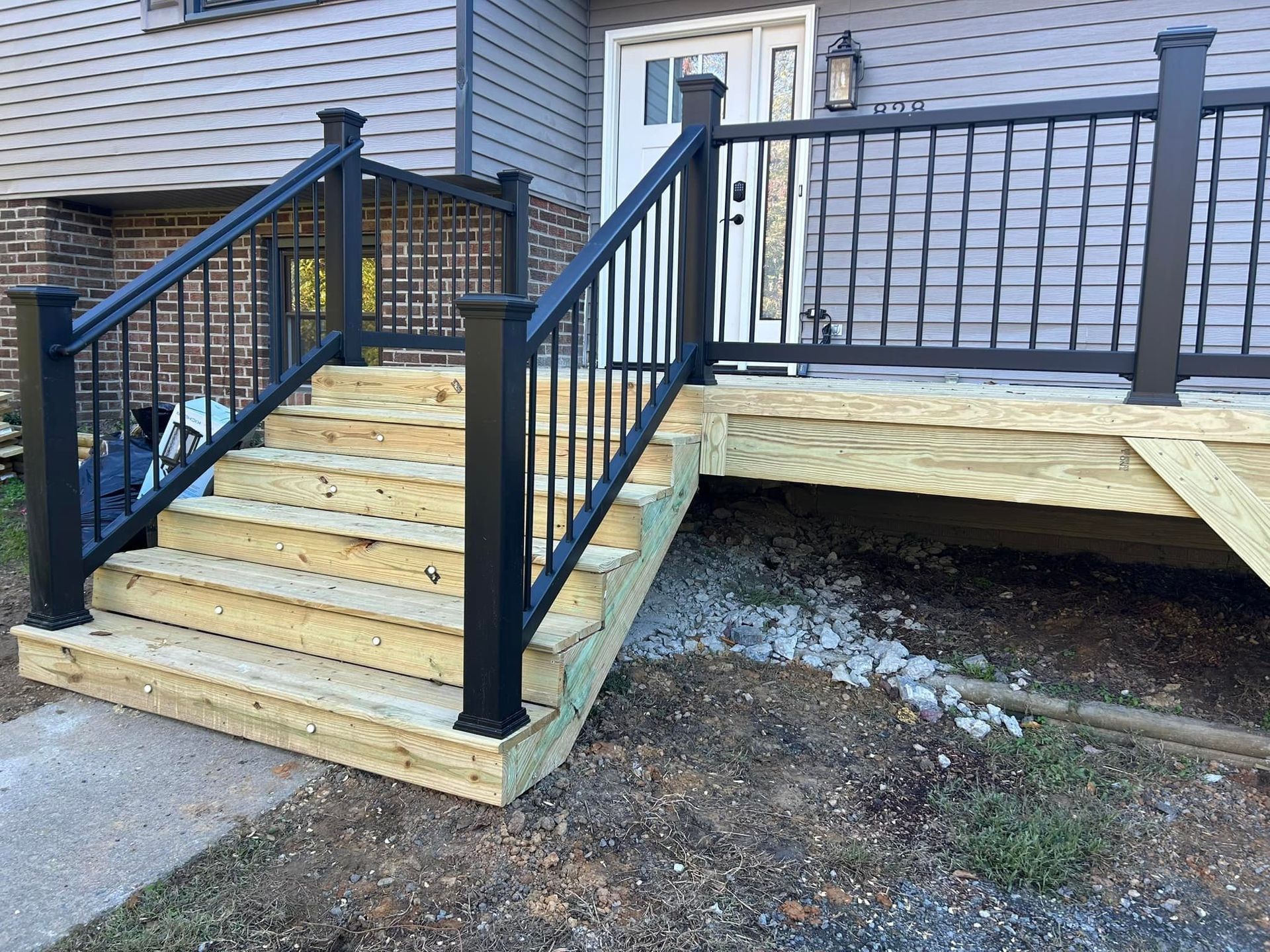 Exterior steps and wheelchair ramp with black railings beside a building entrance