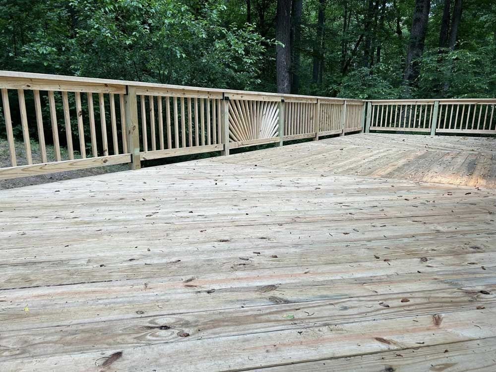 Wooden deck with railing overlooking a wooded area