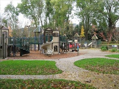A playground in a park with trees in the background