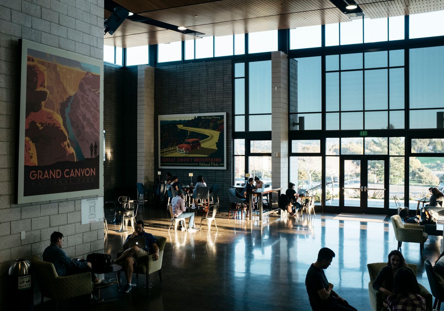 A large room with a lot of windows and people sitting in chairs.