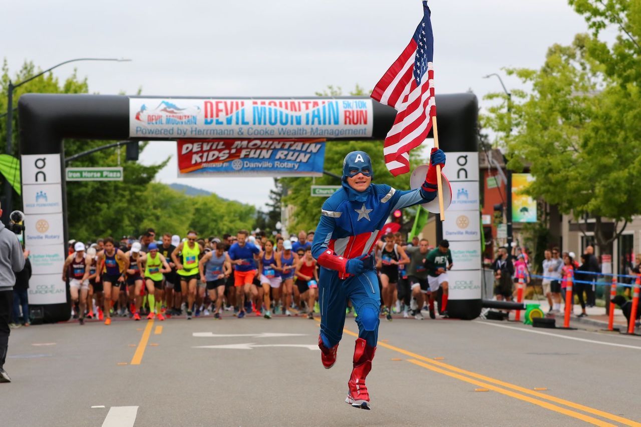 A man dressed as captain america is running in a race