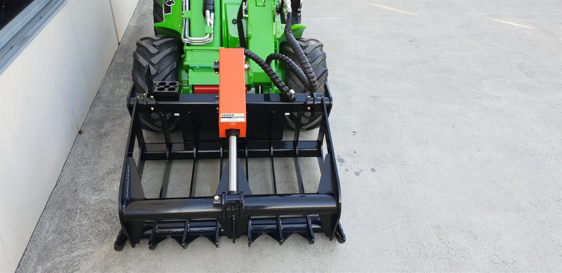 A Green and Black Industrial Front-end Loader With a Grapple — Lawn Care in Umina Beach, NSW