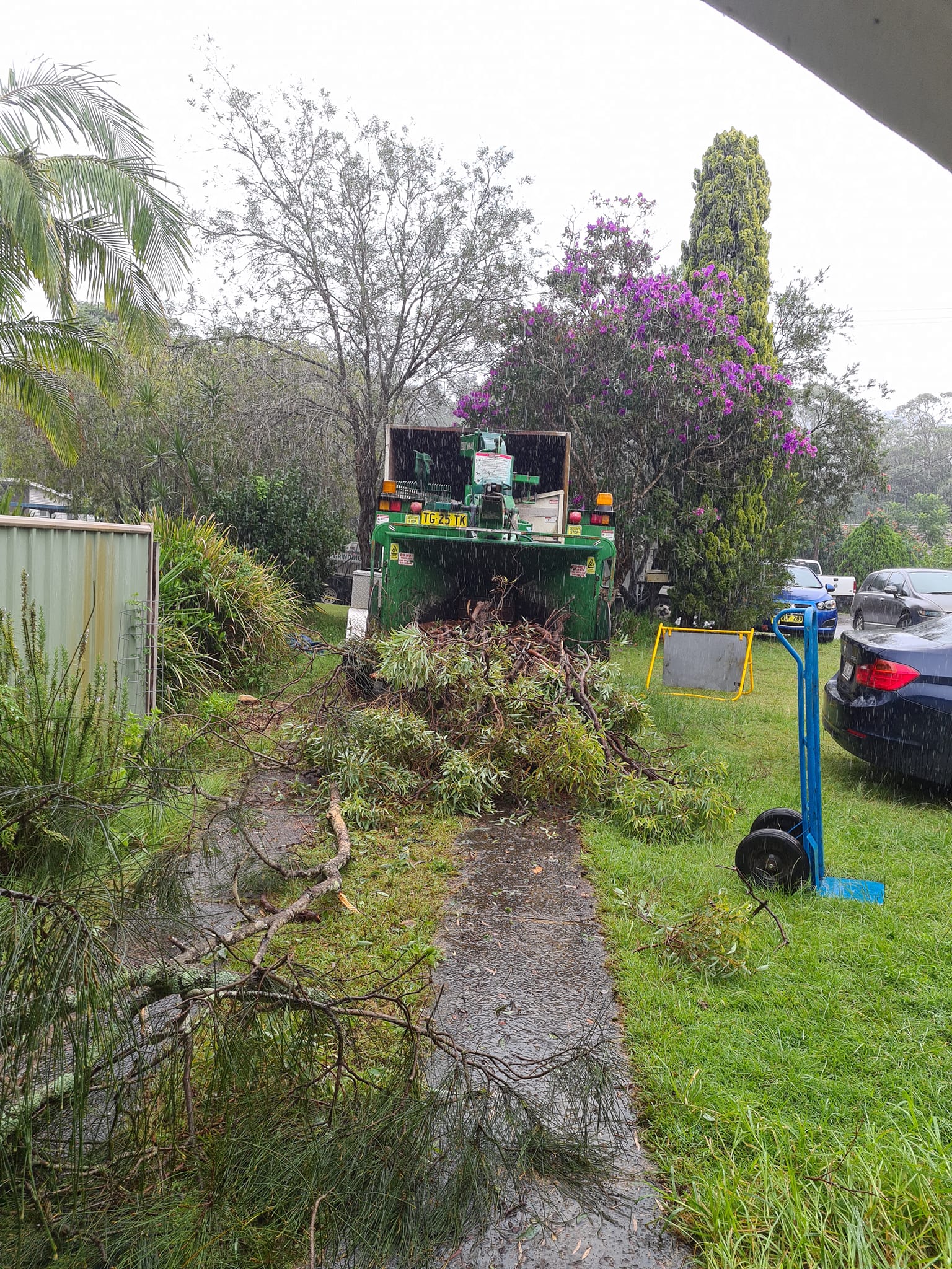Green Wood Chipper Processing Yard Waste Outdoors — Lawn Care in Umina Beach, NSW