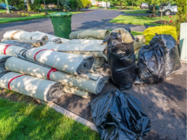 Carpet rolls and garbage bag that needs to be picked up to the garbage disposal
