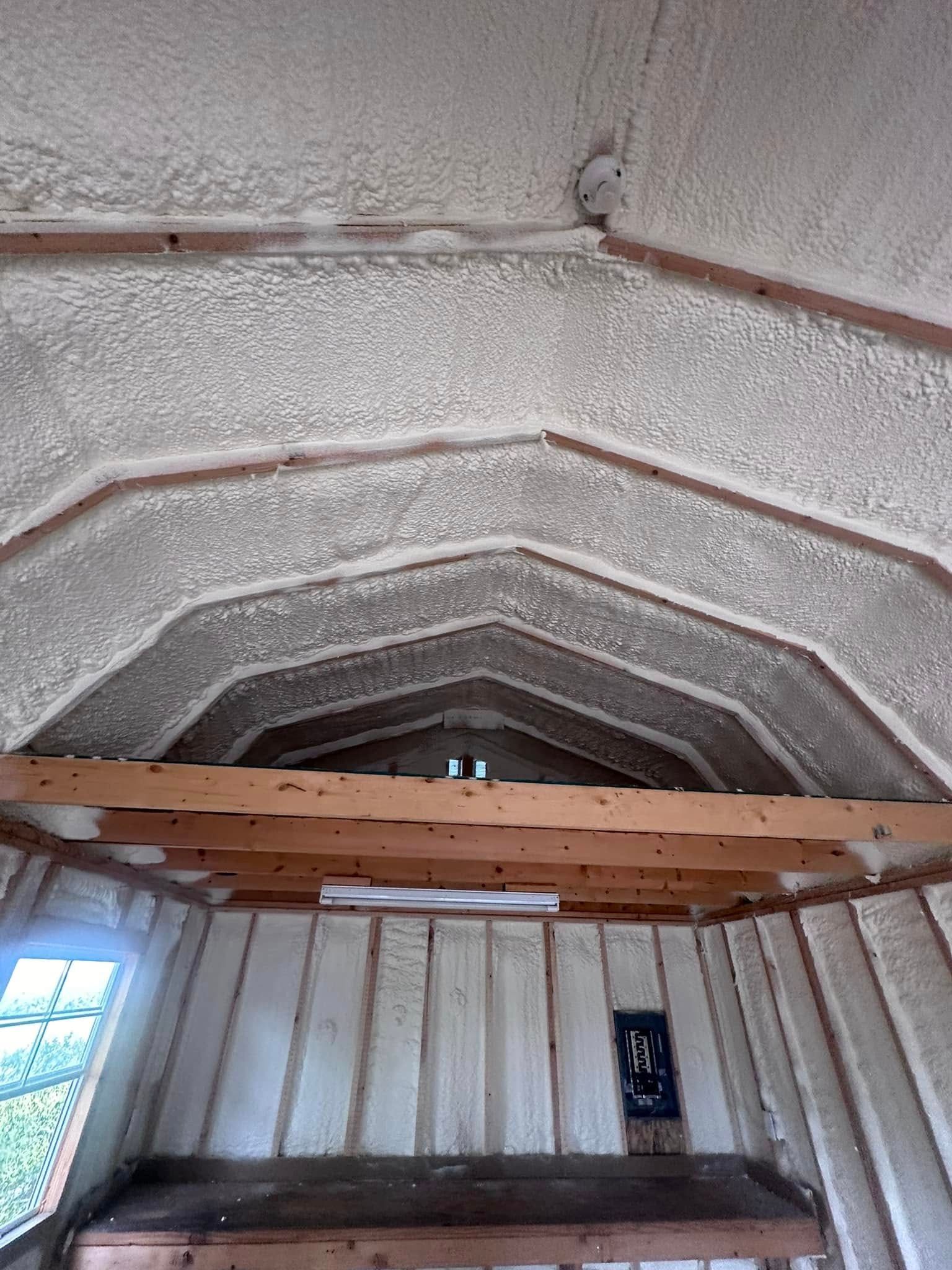 Arched stone ceiling inside a small room with white paneled walls and a wooden beam.