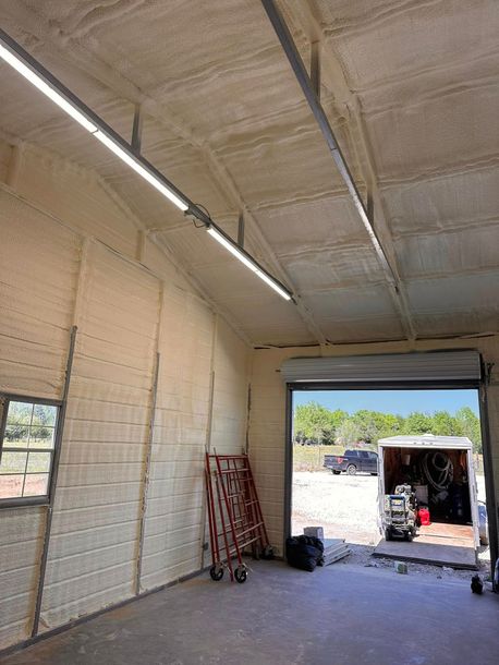 Empty warehouse interior with insulated ceiling, open loading bay, and a truck visible outside