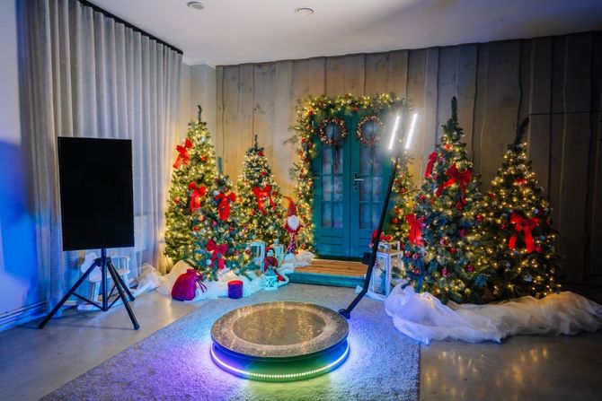 Festive room with three decorated Christmas trees, blue-lit backdrop, and a round platform in the center