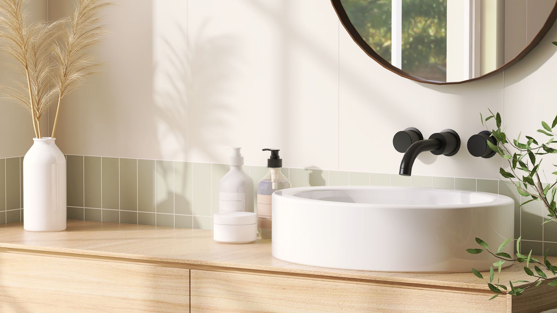 Salle de bains avec lavabo blanc, robinet noir, miroir rond et meuble-lavabo en bois.