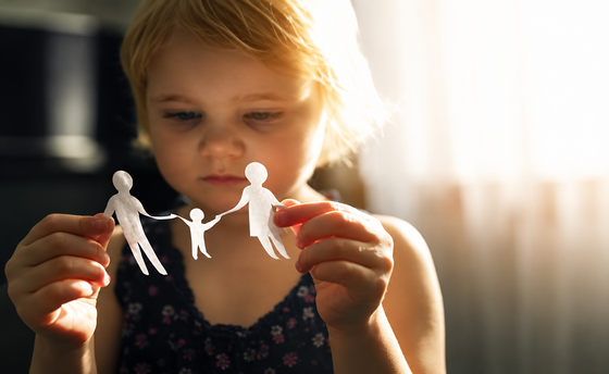 Child holding paper dolls in warm light Child holding paper dolls in warm light
