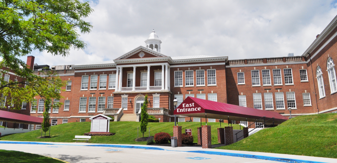 A large brick building with a red awning in front of it