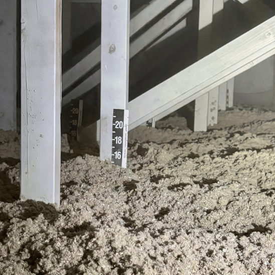 Snow piled under a porch railing with a thermometer reading below zero.