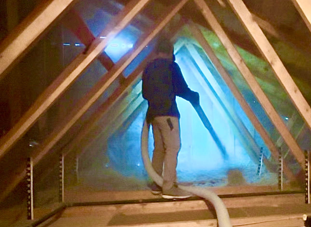 Pacific Insulation crew member blowing fresh cellulose insulation into a remediated attic
