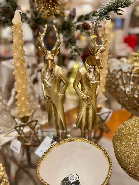 Gold Christmas ornaments and white dish on a festive holiday display table