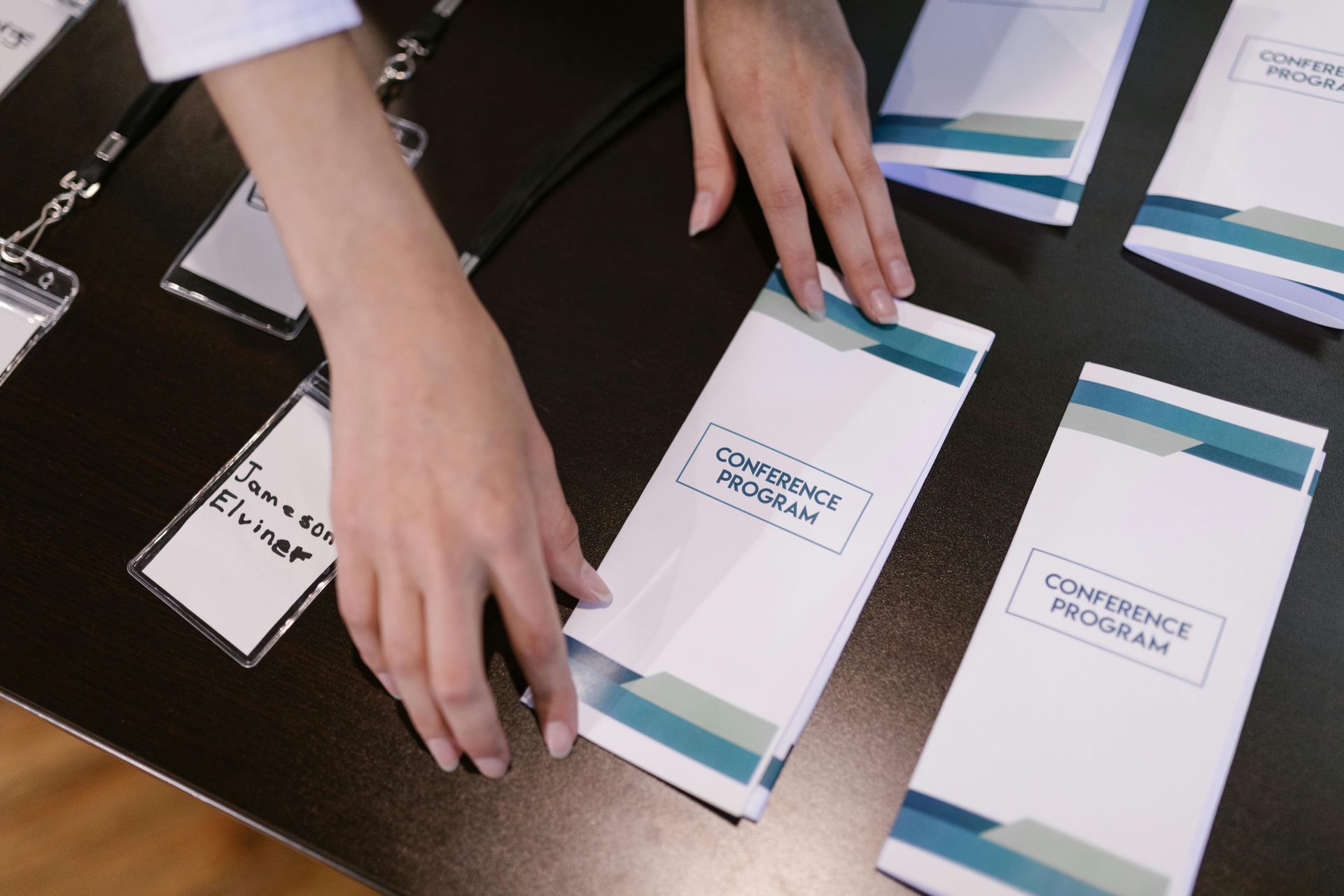 A person is putting a conference program on a table