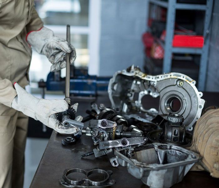 A man is working on a car engine in a garage.