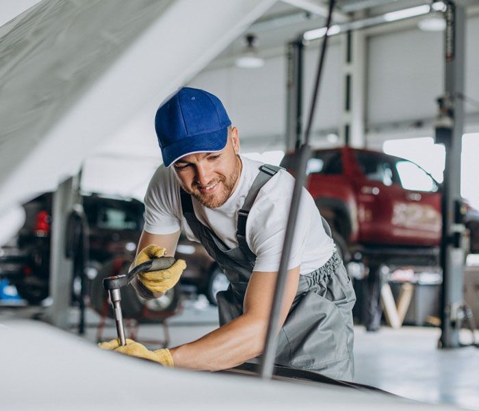 A man is working on a car in a garage.