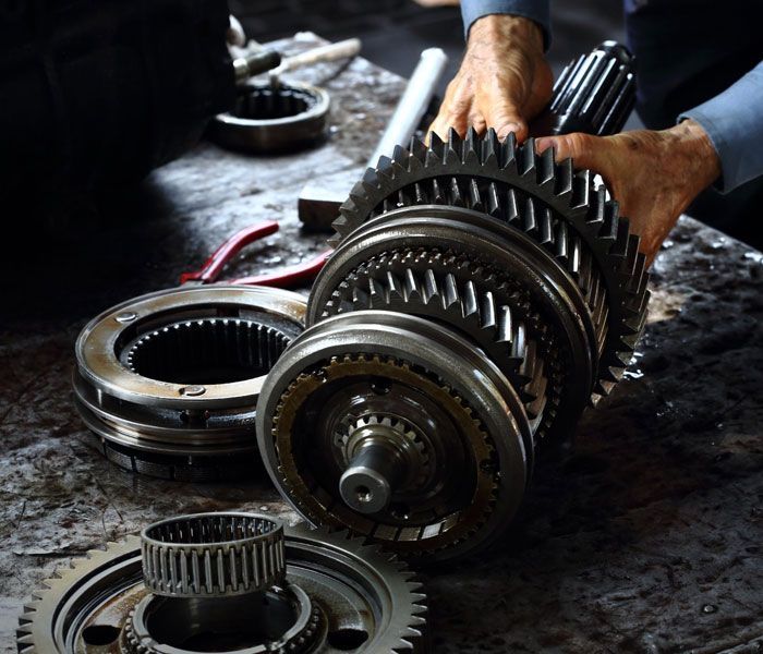 A man is working on a gearbox on a table