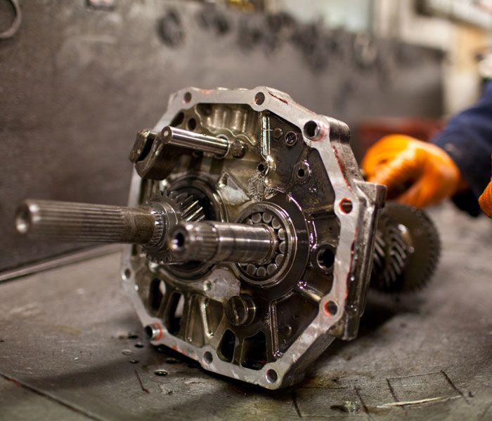 A person is working on a gearbox on a table.