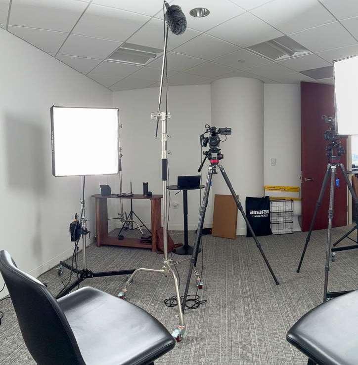 A woman is standing in front of a green screen in a studio. Video filmmaking and storytelling by Sarah Rosie Studios.